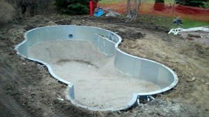 An empty vinyl liner pool under construction by Legendary Escapes