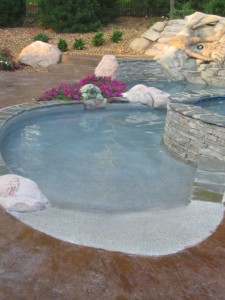 Beach entry on a custom gunite swimming pool built by Legendary Escapes in Highland, Michigan